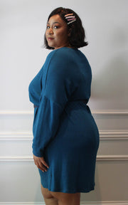 Side view of plus size model in oversized sweater dress