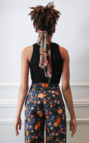 Back view of model in cropped tank and printed trousers