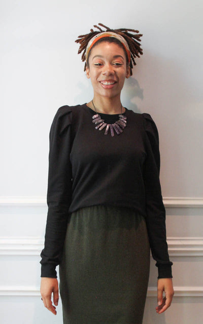 Model wearing puff sleeve sweatshirt against a white wall