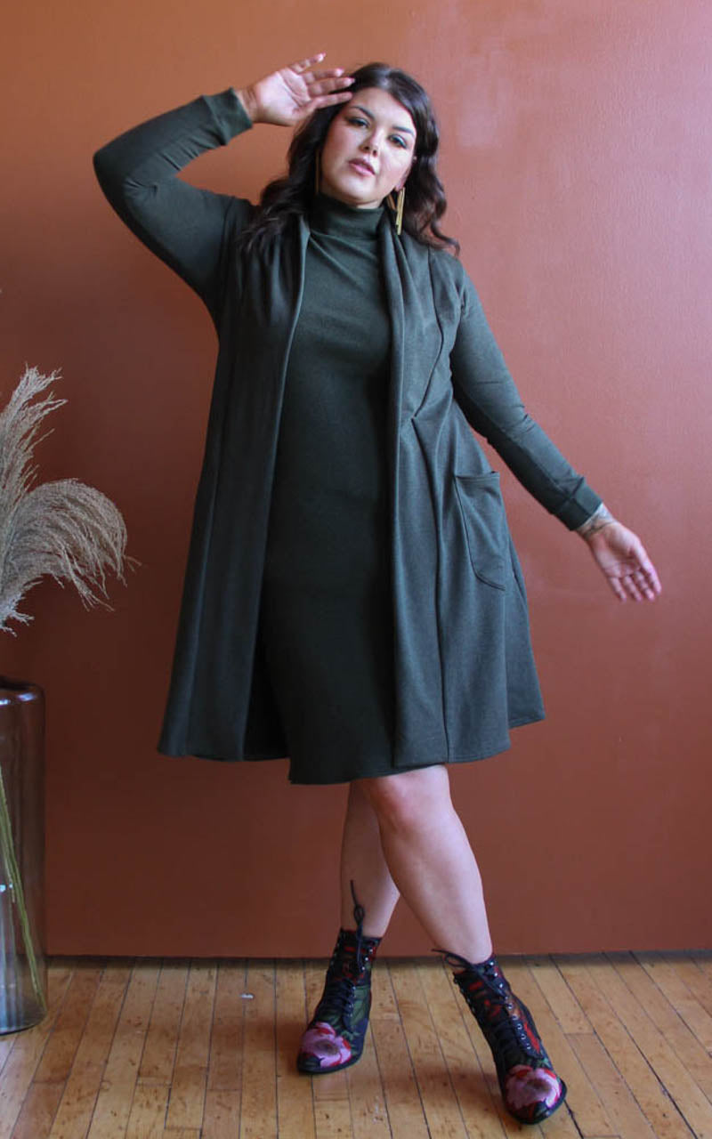 Plus size model in dramatic pose wearing a long cardigan and turtleneck dress