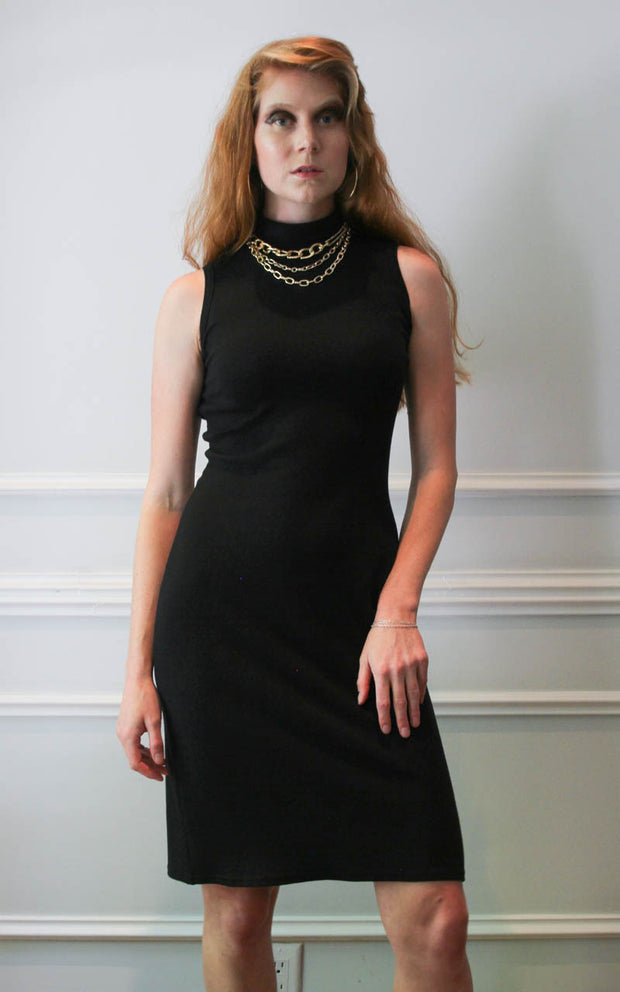 Model standing in a black turtleneck dress