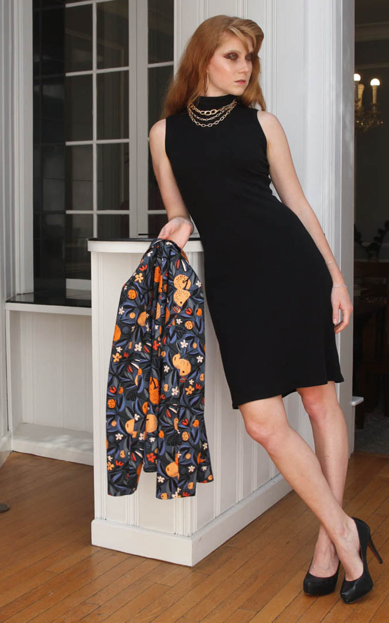 Model leaning on a counter in a turtleneck dress