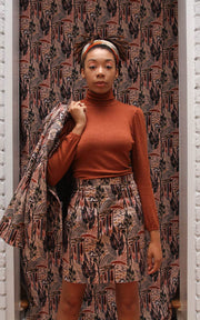 Model in matching printed miniskirt and jacket layered over puff sleeve turtleneck